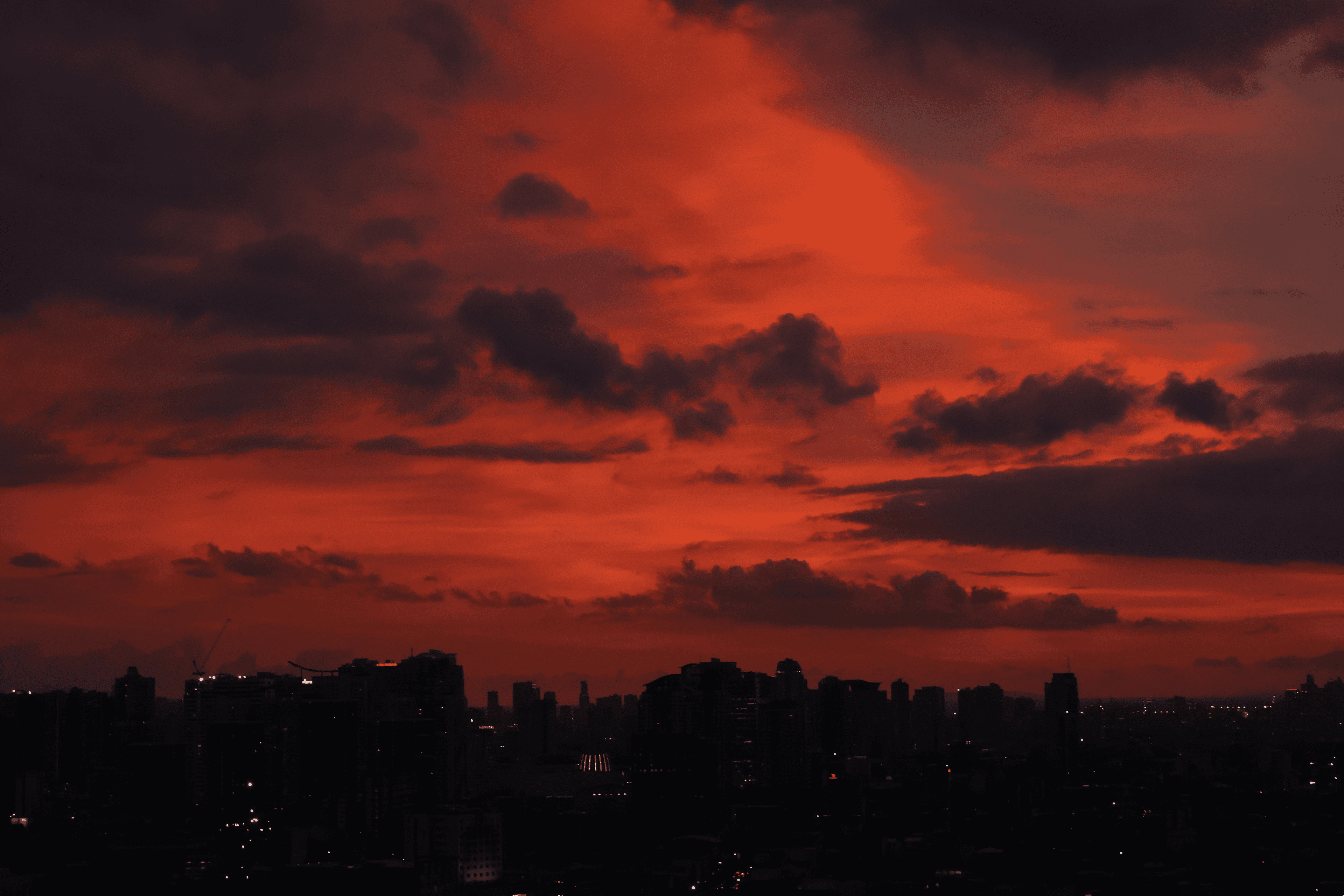 Red sunset clouds over a city skyline